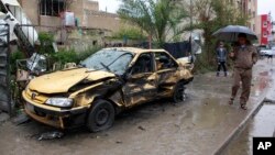 Seorang warga sipil Iran memeriksa lokasi ledakan bom mobil di wilayah komersial Hurriyah, utara Baghdad, Senin (3/2).