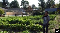 Farmer Pabi Tiwari, who moved to Oregon from a Nepalese refugee camp, enjoys a lemon cucumber fresh from the fields.