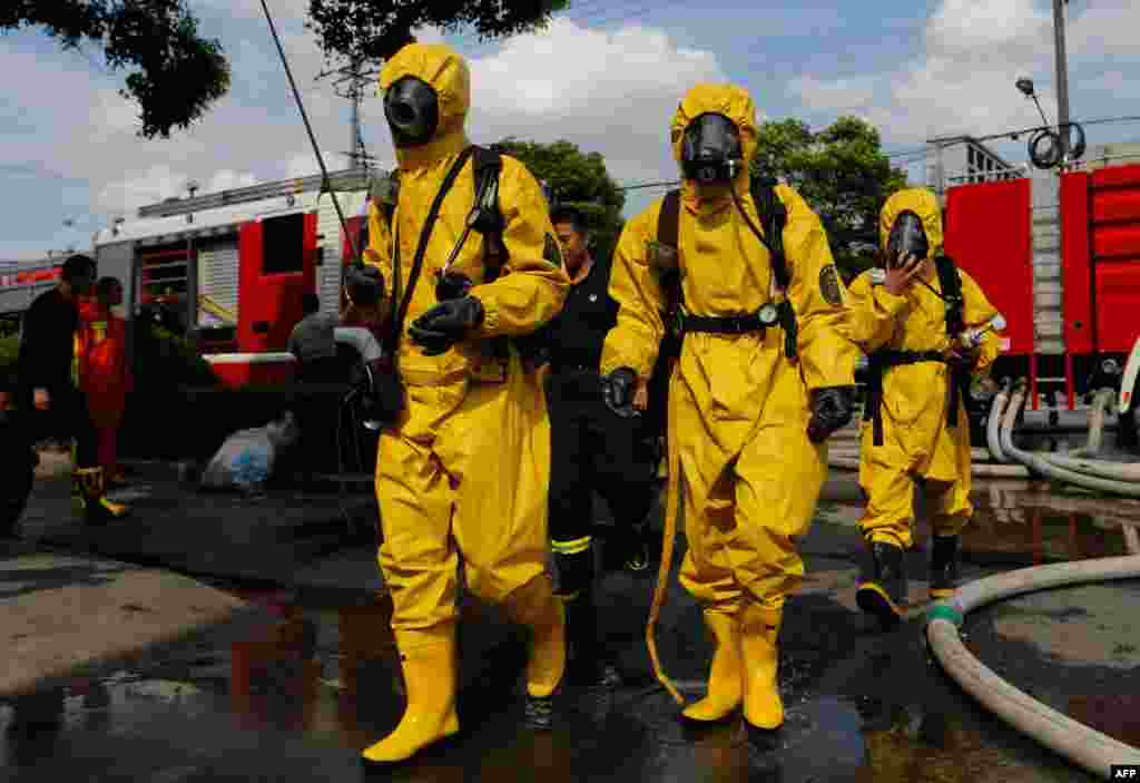 Firemen in protective suits walk near the site of an amonia leak at a cold storage unit in Baoshan district of Shanghai, China. The ammonia leak killed 15 people and sickened dozens, the city government said.