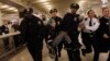 Occupy Wall Street activist Lauren Digioia is detained by police during a demonstration against the National Defense Authorization Act in New York's Grand Central Station, Jan. 3, 2012.