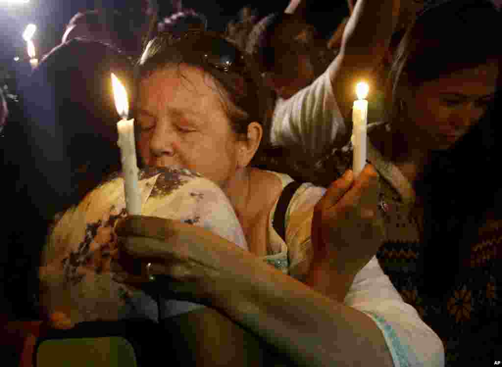 People hold candles to pray for death row prisoners in Cilacap, Indonesia early Wednesday, April 29, 2015.