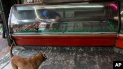 Un empleado coloca carne de cerdo en un refrigerador de una tienda en Caracas, Venezuela. Foto de archivo. Oct. 27 de 2017.