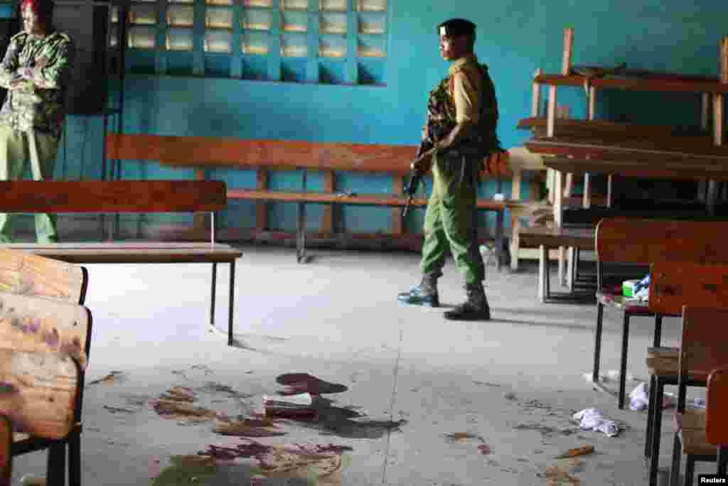 A Kenyan policeman walks past blood stains on the floor of a church after an attack by gunmen on worshippers, Mombasa, Kenya,&nbsp; March 23, 2014. 