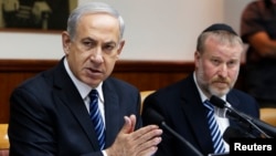 Israel's Prime Minister Benjamin Netanyahu (L) speaks during the weekly cabinet meeting in Jerusalem, May 19, 2013. 