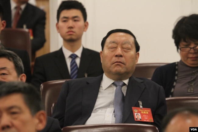 A delegate at Chinese People's Political Consultative Conference takingb a nap.