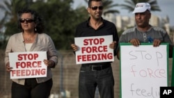 Israeli Arab supporters of Mohammed Allan, a Palestinian prisoner on a hunger strike, hold signs during a support rally, in Ashkelon Israel, Aug. 11, 2015.