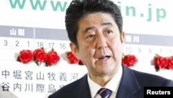 ອະດີດ​ນາຍົກ ລັດຖະມົນຕີ Shinzo Abe ຜູ້ນໍາພາພັກພັກ​ເສລີ​ປະຊາ​ທິປະ​ໄຕ ຫຼື LDP ຊຶ່ງເປັນພັກຝ່າຍຄ້ານໃຫຍ່ໃນຍີ່ປຸ່ນ ຢືນຢູ່ຕໍ່ໜ້າກະດານປະກາດຜົນເລືອກຕັ້ງ ທີ່ສໍານັກງານຂອງພັກ LDP ທີ່ກຸງໂຕກຽວ ໃນວັນທີ 16 ທັນວາ 2012.