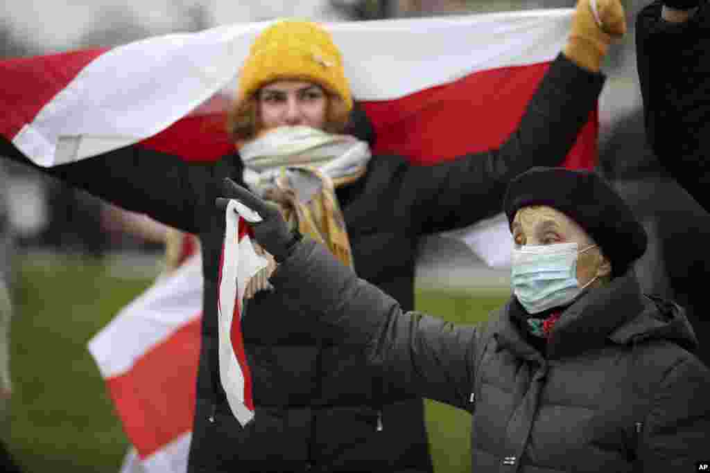 Жінка з червоно-білим прапором на протесті у неділю у Мінську.