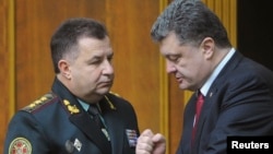 Pejabat keamanan Ukraina Stepan Poltorak (kiri) berbicara dengan Presiden Petro Poroshenko di Kyiv (foto: dok).