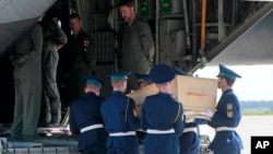 우크라이나 크하르키브 공항에서 우크라이나 의장대가 말레이시아 여객기 희생자 시신을 네델란드행 수송기에 싣고 있다.
