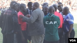 FILE: Highlanders acting chairman Modern Ngwenya pleads with second assistant referee Thomas Kusosa to return to the touchline after the match official was pelted with missiles.