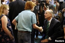 FILE - Texas Gov. Greg Abbott greets members of the community before prayer services at the Arcadia First Baptist Church in Santa Fe, Texas, May 20, 2018. A shooting at Santa Fe High School two days earlier left eight students and two substitute teachers dead.