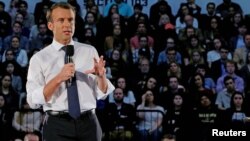 French President Emmanuel Macron answers a question from student in the audience during a town hall meeting at George Washington University in Washington, April 25, 2018. 