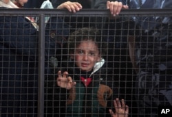 A Palestinian girl waits with her family for their turn to enter the Rafah border crossing with Egypt, in the southern Gaza Strip, May 11, 2016.