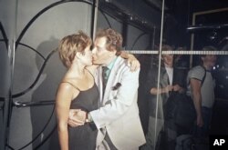 FILE - Carrie Fisher gives her father, Eddie Fisher, a happy birthday kiss at Stringfellow's in New York, Aug. 11, 1988. The daughter threw her father the party in honor of his 60th birthday.