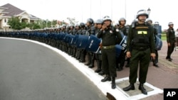 Cambodian riot police stand on a street awaiting the arrival of opposition supporters marching to the U.N. human rights office, in Phnom Penh, Cambodia, Wednesday, Oct. 23, 2013. Thousands of Cambodian opposition supporters began a three-day rally Wednesday to protest what they say was a rigged election and the illegitimate return to power of Prime Minister Hun Sen. (AP Photo)