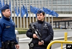 Police patrol the EU commission building, after a bomb exploded nearby, at the subway in Brussels, Belgium, March 22, 2016.
