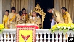 FILE - Thai King Bhumibol Adulyadej, center, is surrounded by his family members (L-R) Princess Somsavali, his daughter Princess Ubolratana, his daughter Princess Chulabhorn, Princess Siribhachudabhorn, Royal Consort Princess Srirasm, his grandson Prince Dipangkorn Rasmijoti, his son Crown Prince Vajiralongkorn and his daughter Princess Sirindhorn after addressing the crowd from a balcony of the Ananta Samakhom Throne Hall on his 85th birthday in Bangkok, Dec. 5, 2012.