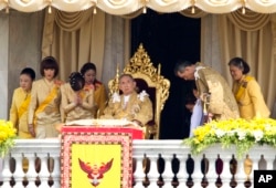 FILE - Thai King Bhumibol Adulyadej, center, is surrounded by his family members, left to right, Princess Somsavali, his daughter Princess Ubolratana, his daughter Princess Chulabhorn, Princess Siribhachudabhorn, Royal Consort Princess Srirasm, his grandson Prince Dipangkorn Rasmijoti, his son Crown Prince Vajiralongkorn and his daughter Princess Sirindhorn after addressing the crowd from a balcony of the Ananta Samakhom Throne Hall on his 85th birthday in Bangkok, Dec. 5, 2012.