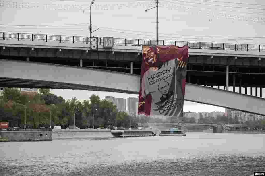 A big sign showing U.S. President Barack Obama wearing a T-shirt wishing Russia&#39;s President Vladimir Putin a happy birthday is seen hanging on a bridge in Moscow. 