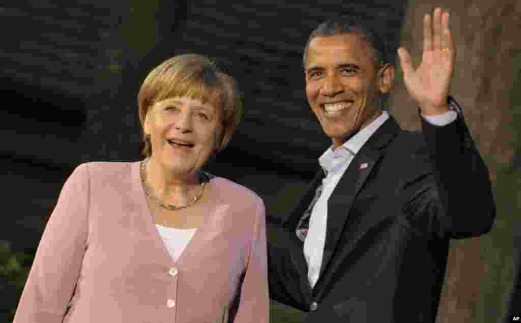 Barack Obama gestures as he greets German Chancellor Angela Merkel May 18, 2012, at the G8 summit at the US presidential retreat at Camp David near Washington, DC.
