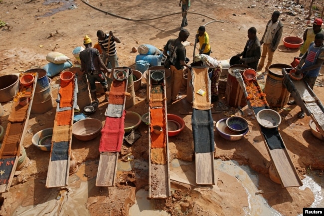 Artisanal miners sluice for gold by pouring water through gravel at an unlicensed mine near the city of Doropo, Ivory Coast, Feb. 13, 2018.