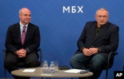 In this image made from video, Kremlin critic Mikhail Khodorkovsky, right, and financier William Browder attend a joint press conference in London, Nov. 20, 2018. They and other Kremlin foes have warned against naming a top Russian police official to lead Interpol.