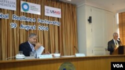 Ashvin Dayal, Associate VP and Asia Managing Director, The Rockefeller Foundation (left) looks over his notes as USAID Asia Regional Development Mission Director Michael Yates at launch of Global Resilience Partnership, Aug. 19, 2014. (Steve Herman/VOA News)