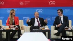 Russia's President Vladimir Putin, center, meets with representatives of G20 Youth Summit, St.Petersburg International Economic Forum, June 20, 2013.