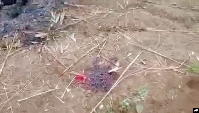 Tangkapan layar dari video menunjukkan bercak darah di tanah dekat sejumlah jenazah yang terbakar di Kota Done Taw, wilayah Sagaing, Myanmar, 7 Desember 2021.