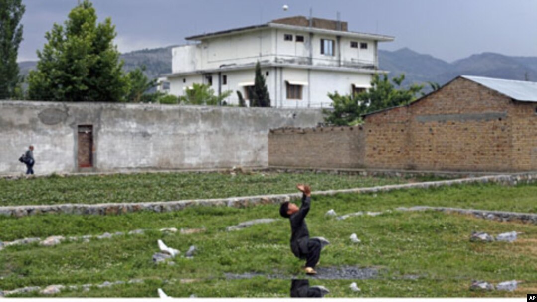 FILE - A boy plays with a tennis ball in front of Osama bin Laden's compound in Abbottabad, Pakistan, May 2011. Osama bin Laden was killed at his compound on May 2, 2011, by a U.S. special forces team.