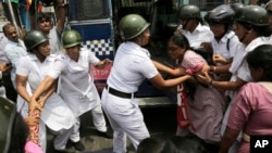 Indian policewomen detain an activist of Socialist Unity Center of India during a daylong nationwide strike in Kolkata, India, Sept. 2, 2015.