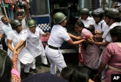 Indian policewomen detain an activist of Socialist Unity Center of India during a daylong nationwide strike in Kolkata, India, Sept. 2, 2015.