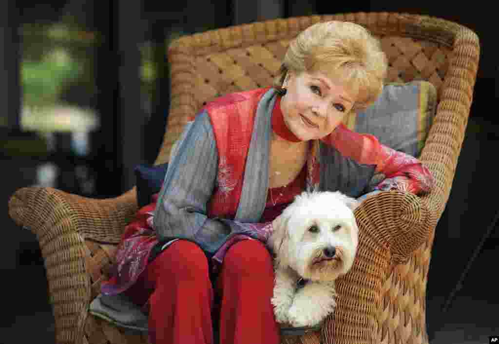 អ្នកស្រី​ Debbie Reynolds តារាសម្តែង​ម្នាក់ក្នុង​ភាពយន្ត &laquo;Behind the Candelabra&raquo; ថត​រូបជាមួយ​ឆ្កែ​របស់​អ្នកស្រី​​ដែល​មាន​ឈ្មោះ​ថា Dwight នៅ​ក្រុង Beverly Hills រដ្ឋកាលីហ្វ័រញ៉ា កាល​ពី​ថ្ងៃទី ២១ ឧសភា ឆ្នាំ ២០១៣។ អ្នកស្រី​សម្តែង​ជា​តួ​ដែល​មាន​ឈ្មោះ​ថា Frances ជាម្តាយ​របស់​អ្នកលេង​ព្យ៉ាណូនិង​អ្នកចម្រៀងលោក Liberace។