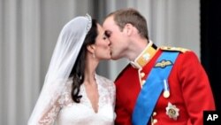 Prince William akimbusu mkewe Kate, Duchess of Cambridge, Buckingham Palace, baada ya kuoana April 29, 2011, mjini London.