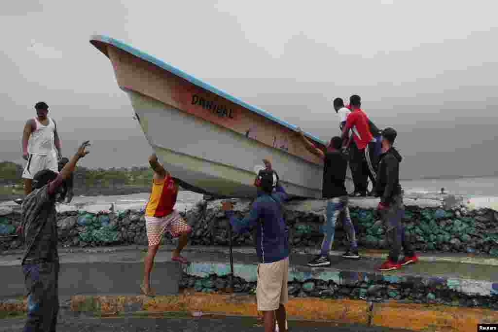 Men take a boat off a beach before the arrival of Tropical Storm Fred in Santo Domingo, Dominican Republic, Aug. 11, 2021.