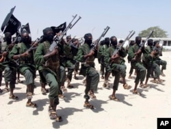 FILE - Hundreds of al-Shabab fighters perform military exercises in the Lafofe area, some 18 km south of Mogadishu, Somalia. Al-Shabab has been identified as both an internal threat to Somalia as well as an international threat due to its al-Qaida links.