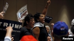 Protesters shout as they are escorted out of the building during U.S. Republican presidential candidate Donald Trump's campaign rally at the Tampa Convention Center in Tampa, Florida March 14, 2016. 