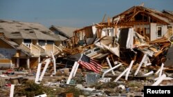 An American flag flies amongst rubble left in the aftermath of Hurricane Michael in Mexico Beach, Florida, Oct. 11, 2018. 