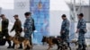Police officers with sniffer dogs trained to search for explosives, patrol at the Olympic Park in the Adler district of Sochi, Jan. 28, 2014. 