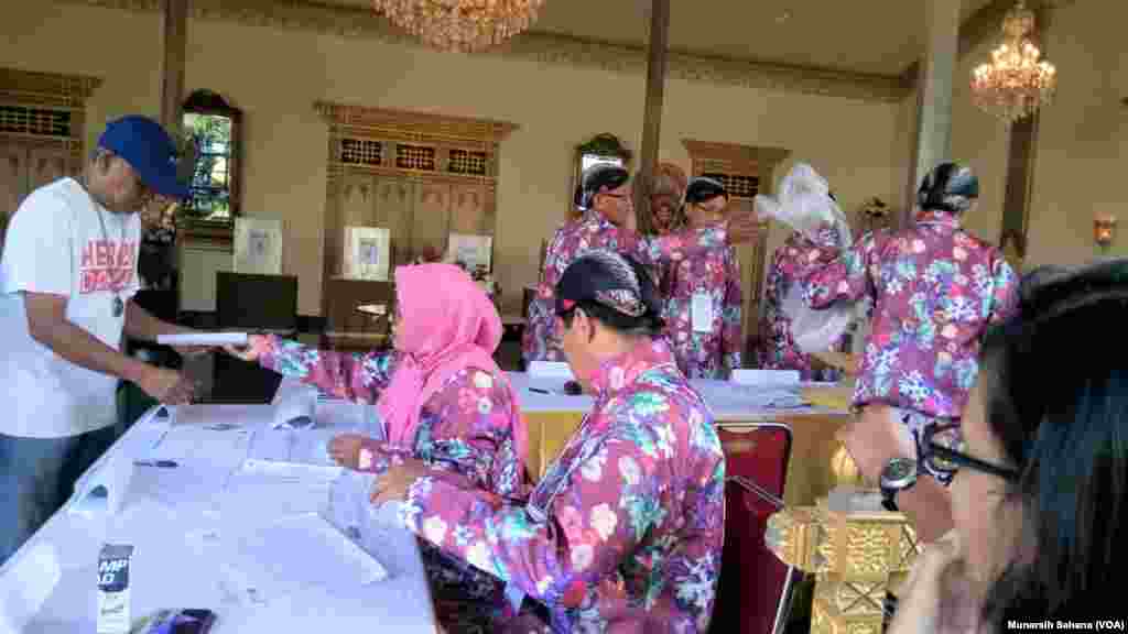 Petugas TPS 15 di Kelurahan Panembahan, Kecamatan Kraton, Yogyakarta, berbusana tradisional Jawa bersiap membuka TPS, Rabu, 17 April 2019. Gubernur DIY Sultan Hamengkubuwono X mencoblos di TPS ini. (Foto: Munarsih S./VOA)