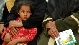A woman holds a card in her lap about the problems with female genital mutilation (FGM) during a session to educate women in Minia, Egypt June 13, 2006.