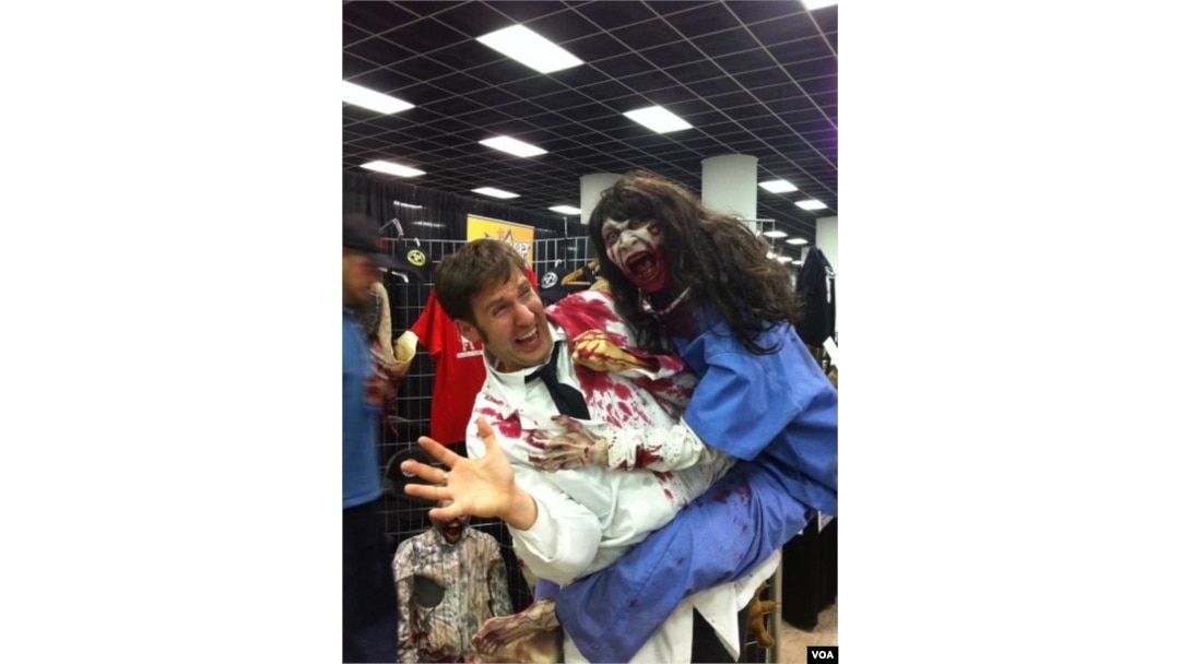 Seorang pria memegang boneka zombie di konvensi Walker Stalker di Atlanta, Georgia. (VOA/Marissa Melton)