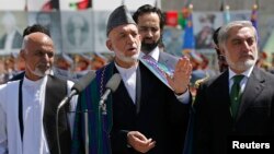 Afghan President Hamid Karzai, center, calls for resolution in presidential election. He's flanked by candidates Ashraf Ghani, left, and Abdullah Abdullah in Kabul Aug. 19, 2014.