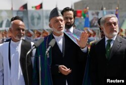 Afghan President Hamid Karzai, center, calls for resolution in presidential election. He's flanked by candidates Ashraf Ghani, left, and Abdullah Abdullah in Kabul Aug. 19, 2014.