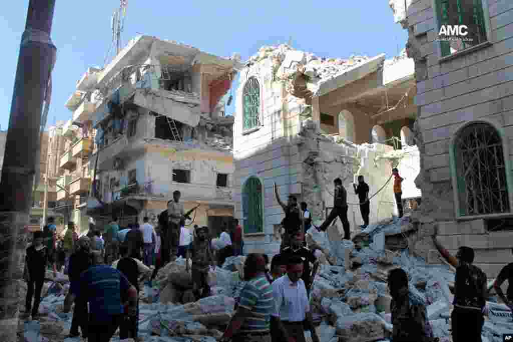 In this June 29, 2013 citizen journalism image, Syrian rebels inspect the rubble of damaged buildings due to a surface-to-surface missile launched by Syrian forces in Aleppo, Syria.