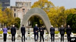 U.S. Secretary of State John Kerry, center left, puts his arm around Japan's Foreign Minister Fumio Kishida, center right, after they and fellow G7 foreign ministers laid wreaths at the cenotaph at Hiroshima Peace Memorial Park in Hiroshima, western Japan