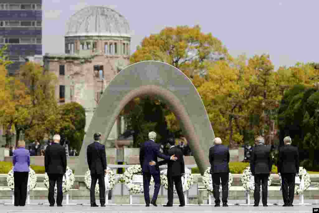 U.S. Secretary of State John Kerry, center left, puts his arm around Japan&#39;s Foreign Minister Fumio Kishida, center right, after they and fellow G-7 foreign ministers laid wreaths at the cenotaph at Hiroshima Peace Memorial Park in Hiroshima, Japan, April 11, 2016.
