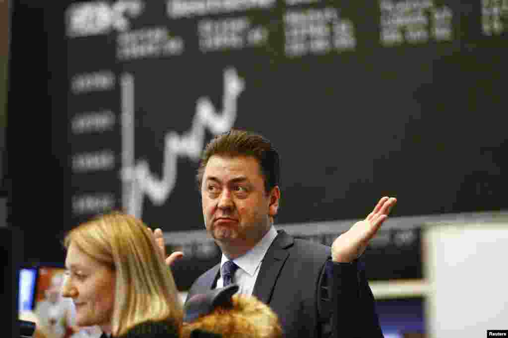 A trader reacts to activity on the German DAX Index board. European stock index futures fell early on Monday as Greece&#39;s Syriza party promised to roll back austerity measures after sweeping to victory in a snap election, Frankfurt stock exchange, Jan. 26, 2015.