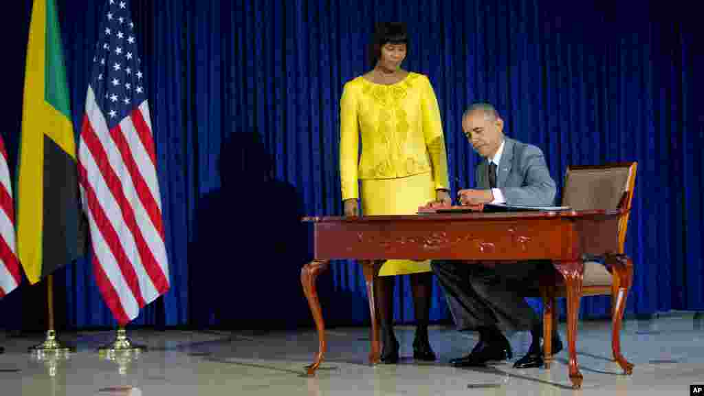 Le président Barack Obama, accompagné par le Premier ministre jamaïcain Portia Simpson-Miller, signe le livre d&#39;or avant leur rencontre bilatérale à la Maison de la Jamaïque, le jeudi 9 Avril, 2015 Kingston, en Jamaïque.